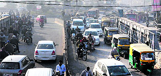 Heavy rush at the busy Bbandari bridge; and (right) schoolchildren commute on a rickshaw as fog envelops the city during the morning hours in Amritsar on Thursday