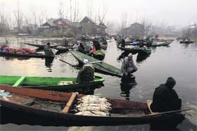 Floating market: Kashmiri vendors sell vegetables at the Dal Lake in Srinagar on Thursday