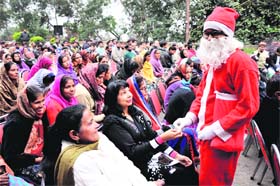 A boy dressed as Santa Claus distributes sweets at Christmas celebrations in Jammu on Thursday