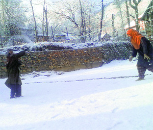 Girls enjoy the first snowfall of the season  in Anantnag by throwing snowballs at each other on Friday. 
