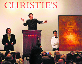 An auctioneer displays a work by artist Vasudeo S Gaitonde, which went for Rs 23.7 crore at the British auction house Christies maiden sale in Mumbai on Thursday. 