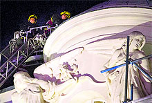 Policemen inspect the roof of the Apollo Theatre after a part of it collapsed in central London on Thursday night
