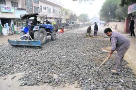 Re-carpeting work under way on the potholed road at the Paras Ram Nagar in Bathinda on Saturday