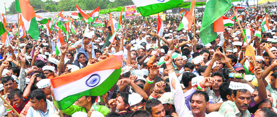Supporters of anti-corruption activist Anna Hazare (below) wave the national flag during his 10-day hunger strike at the Ramlila Grounds in New Delhi in August 2011.