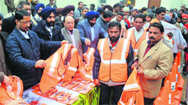 (Left to right) Anil Joshi, Local Bodies Minister, DPS Kharbanda, MC Commissioner, Bakshi Ram Arora, Mayor, distribute new uniforms and safety equipment to MC employees in Amritsar on Sunday.