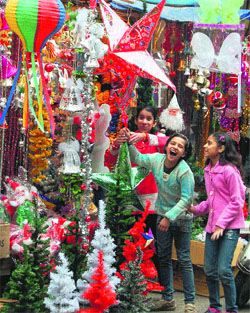 Children look at Christmas accessories on display in shops in Amritsar on Sunday.