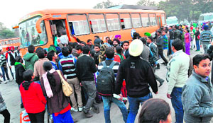 Candidates appearing for the examination of Punjab Food Inspector rush to board a bus at the ISBT in Sector 43, Chandigarh. 