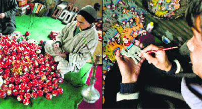 Artists give final touches to handmade Christmas gift items in Srinagar on Sunday.