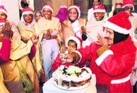Vrindavan widows ring in XMas: Widows of Vrindavan distributing cake during celebration of Christmas first time in their life, at Vrindavan in UP on Sunday