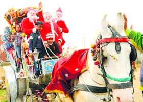 More the merrier: Santa Claus enjoy a ride with children during a carnival at Delhi Public School in Patiala on Sunday
