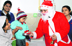 Santa Claus presents a gift to a child undergoing treatment at the General Hospital in Panchkula on Monday. Tribune photo: Nitin Mittal