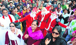 Christmas revellers participate in a procession in Mandi on Monday.