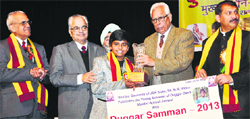 Governor NN Vohra felicitates a young achiever in Jammu on Monday. Tribune Photo: Anand Sharma