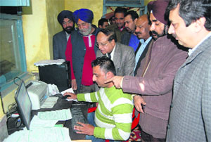 Officials monitor the computerised issuing process of birth and death certificates at Town Hall in Amritsar on Tuesday.