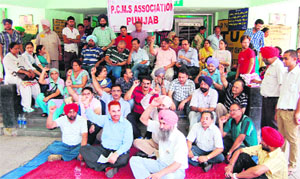Members of PCMS Association Punjab raise slogans against the state government outside the civil hospital in Amristar