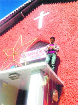 A man puts up lights to illuminate the Central Methodist Church on the eve of Christmas in Nainital on Tuesday