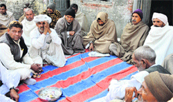 Grief-stricken members of Ravinders family sit at the chaupal of Kutel village in Karnal district on Tuesday. Tribune photo: Ravi Kumar
