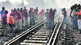 Workers repair the rail track after a wagon of an Army train derailed near the railway station.