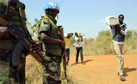 A UN peacekeeper stands guard as civilians move towards a UN refugee camp on Monday