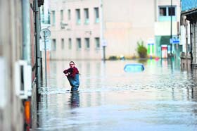 Storm batters France: A man walks through a flooded street in Britanny on Tuesday