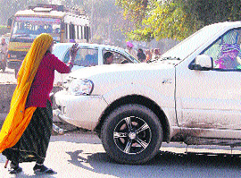 A beggar asks for aims at a traffic signal near the railway station in Amritsar on Wednesday. 