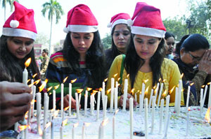 Girls light candles outside the Sacred Heart Cathedral on the occasion of Christmas Day in New Delhi on Wednesday.