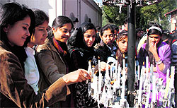 Women light candles at St Francis Church on Christmas in Dehradun on Wednesday; and (right) devotees during a ritual at the church