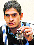Arun Kumar shows off his silver medal won in Asia Pacific Cricket Tournament