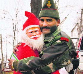 Yuletide bonhomie: A man dressed as Santa Claus greets an Army jawan on Christmas at Bhimber Gali along the Line of Control in Poonch district, about 250 km from Jammu, on Wednesday