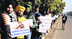 Computer teachers and data entry operators form a human chain to mark their protest on the road dividing Sectors 16 and 17 in Chandigarh on Thursday. Tribune Photo: Pradeep Tewari