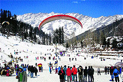 Tourists enjoy in the Solang valley,13 km from Manali, on Thursday