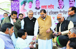 Ellenabad MLA Abhey Singh Chautala and state INLD president Ashok Arora distribute identity cards among party workers in Sirsa on Thursday. 