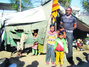 Rajesh Kumar and his family in front of the worn-out tent in Hisar on Thursday. 