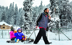 Children enjoy a sledge ride in Gulmarg on Thursday. Tribune Photo: Amin War