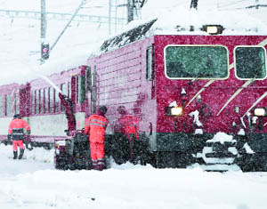 Workers clear the tracks at the railway station in Disentis, Switzerland, on Thursday.