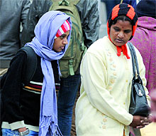 Women have wrapped up warmly in woollens as cold waves sweep the city on Friday