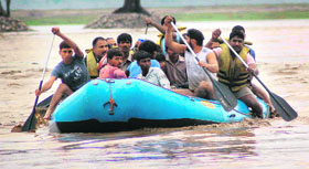 Policemen rescue slum dwellers of the Bairagi camp during the mid-June natural calamity in Uttarakhand.