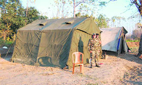 NDRF personnel stand guard outside a tent at Sarai village in Haridwar on Friday.