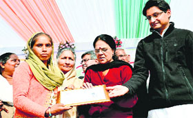 Union Minister Girija Vyas gives away a certificate of ownership to a beneficiary under the Rajiv Awas Yojna at Sirsa on Friday.