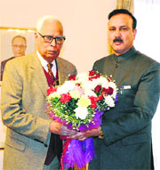 Minister of State for Industries and Commerce Sajjad Ahmad Kichloo presents a bouquet to Governor NN Vohra ahead of their meeting in Jammu