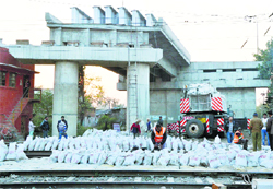 Workers prepare for the laying of concrete girders on the Lakkar Bridge in Ludhiana on Friday. Photo: Inderjeet Verma