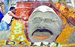 An artist makes sand sculpture of Aam Aadmi Party convener Arvind Kejriwal on the banks of Sangam in Allahabad on Friday