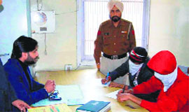 Sushant Bhatia, Superintendent, House Tax Department, MC, (left) questions the youths in Amritsar.