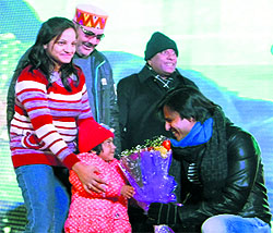 Bollywood actor Vivek Oberoi greets a child during the Winterlline Carnival in Mussoorie on Saturday
