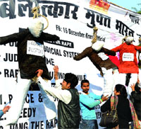 Activists hang the effigies of rapists during a demonstration to mark the first death anniversary of theDelhi gangrape victim at Jantar Mantar in New Delhi on Sunday.