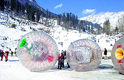 Tourists enjoy Zorbing in the Solang valley, 13 km from Manali