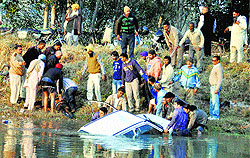 Residents try to pull out the vehicle to rescue the victim from Sidhwan canal in Ludhiana on Sunday