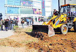 An MC earthmoving machine razes an illegal green belt located opposite Omaxe Mall on Ferozepur Road in Ludhiana on Sunday