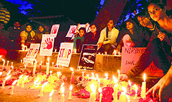 People light candles to pay tribute to the Delhi gangrape victim on her first death anniversary at Jantar Mantar in New Delhi on Sunday