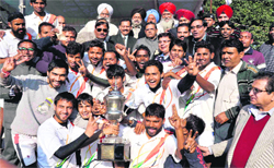 Gurukul Kangri University hockey team with their trophy after defeating FCI, Delhi, at Gurukul Kangri University in Haridwar on Sunday. A Tribune photograph